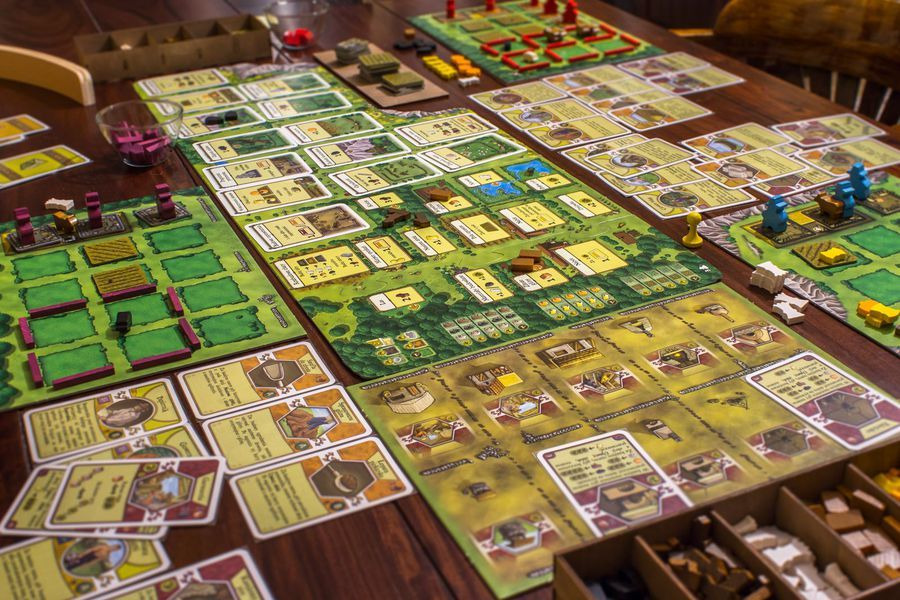 農家樂桌遊進行中的場景，桌上放滿了行動圖板和玩家圖板。(照片取自BGG網站)